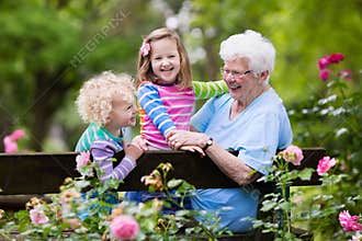 Grandmother and kids sitting in rose garden