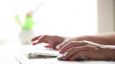 A PC user works at the computer using wireless keyboard and mouse