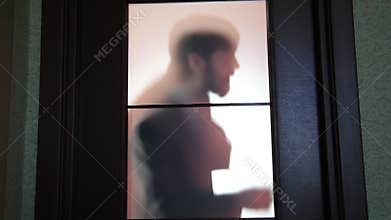 Businessman standing outside the door, preparing to go in, worried