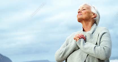 Senior woman meditating on beach