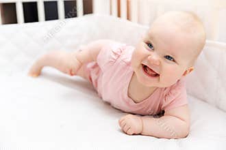 Happy smiling baby girl in crib