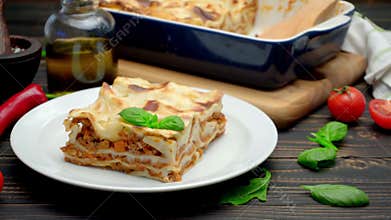 Portion of tasty lasagna on wooden backgound