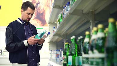 Man buying mineral water in the supermarket
