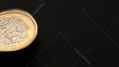 Overhead New UK One pound coin spinning