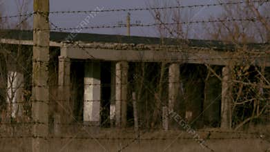 Ruined buildings abroad from barbed wire