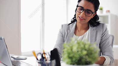 Businesswoman with laptop and calculator at office