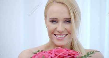 Smiling Blond Woman Smelling Pink Roses