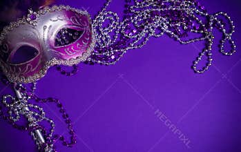Purple Mardi-Gras or Venetian mask on purple background