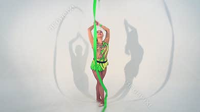 Beautiful acrobat dancing with a sash