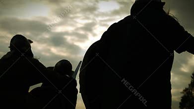 Silhouettes of warriors with swords,axes,shields with lighting sparks