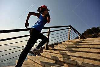 Healthy lifestyle sports woman running up on stone stairs sunrise