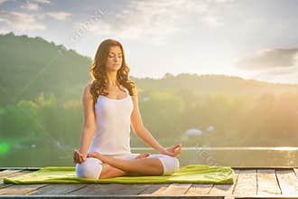 Woman Yoga - relax in nature on the lake