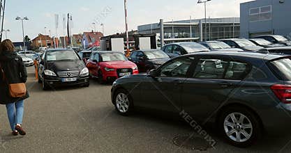 Woman buying new MIN, Mercedes-Benz, Audi car at dealer