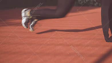 Female doing abdominal mountain climber workout, in slow, motion, on athletic field