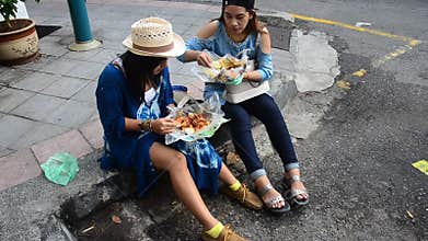 Thai women eating rice topped malaysian curry style