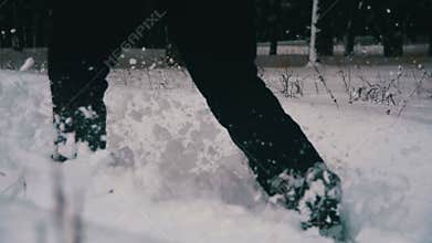 Man Walking in the Deep Snow in the Winter Forest at Snowy Day. Slow Motion