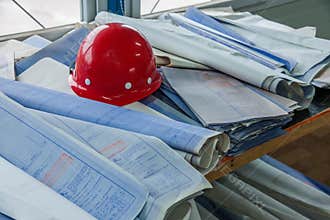 Housing construction site site office construction drawings on the helmets
