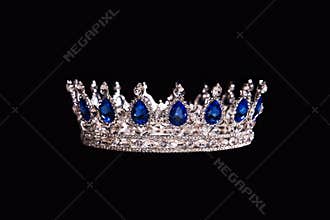 Royal crown with sapphire isolated on black background