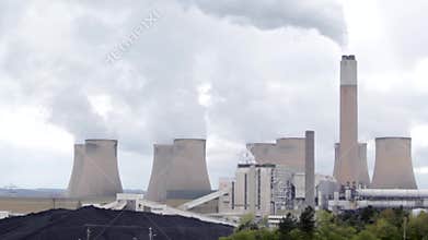 Climate Change in Action from Nuclear Power Station. Billowing polluting clouds reach for the overcast sky.