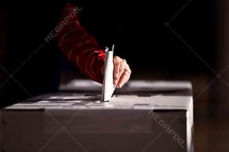 Hand casting a vote into the ballot box