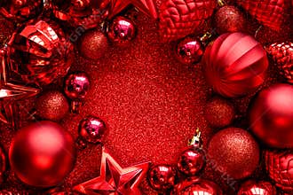 Red Christmas frame. Christmas balls, stars, cones and hearts on red sparkles background. Flat lay. Top view.