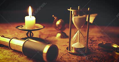 Vintage nautical items on old world map in candlelight