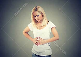 Young woman hands on stomach having bad aches pain. Food poisoning and cramps. Negative emotion face expression health problems