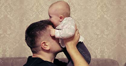 Happy dad plays with his incredibly nice and laughing baby.