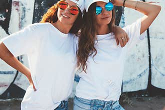 Models wearing plain tshirt and sunglasses posing over street wa