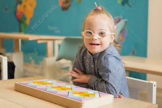 Beautiful girl with down syndrome engaged in class