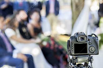 Full Frame reflex DSLR camera over tripod recording the wedding