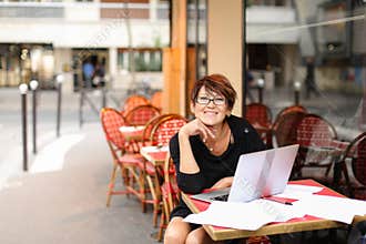 aged female writer working with new book in laptop and have