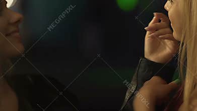 Two pretty females dancing, flirting in nightclub, touching each other gently