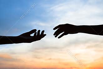 Mercy, two hands silhouette on sky background, connection or help concept