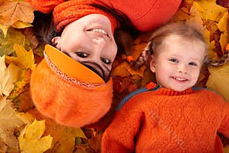 Happy family with child on autumn orange leaf.