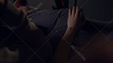 Woman flirting with man in movie theatre. Girl stroking guy on leg with hand