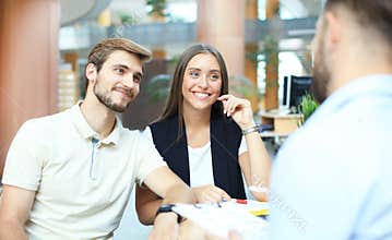 Successful lawyer giving consultation to family couple about buying house.