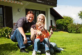 Family sitting in front of their home
