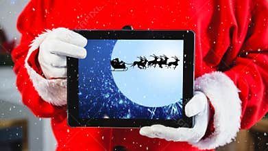 Video composition with snow over torso of santa holding tablet