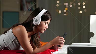 Teen listening to music relaxing on a bed