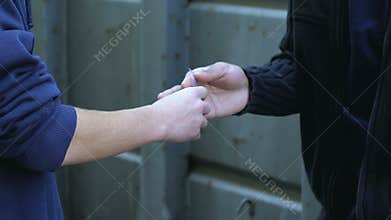 Teen boy buying ecstasy, drug abuse among youth, illegal trafficking on street