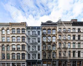 Exterior view of old apartment buildings in the SoHo neighborhood of Manhattan in New York City with empty blue sky