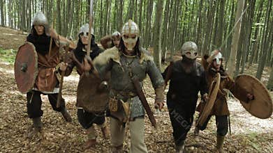 Warriors of Vikings are going in the forest on the battle.
