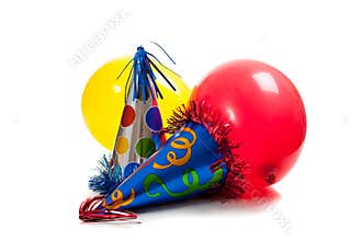 Birthday party hats and balloons on white