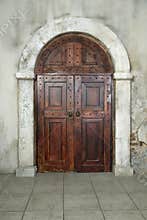 Arched wooden door in a stone wall