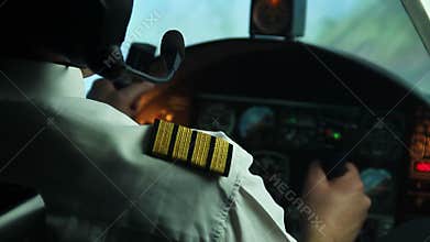 Professional male pilot steering plane, making turn. Responsibility, commitment