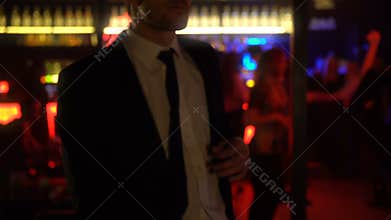 Drunk man in suit dancing carefree in nightclub, relaxed atmosphere, good mood