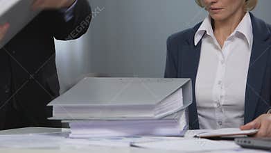 Angry manager throwing folders in front of coworker, women rights in business