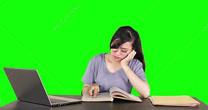 Bored female student reading book