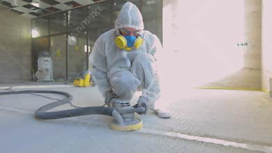 Builders are polishing the floor with special equipment. Concrete surface grinding. Builders at a construction site